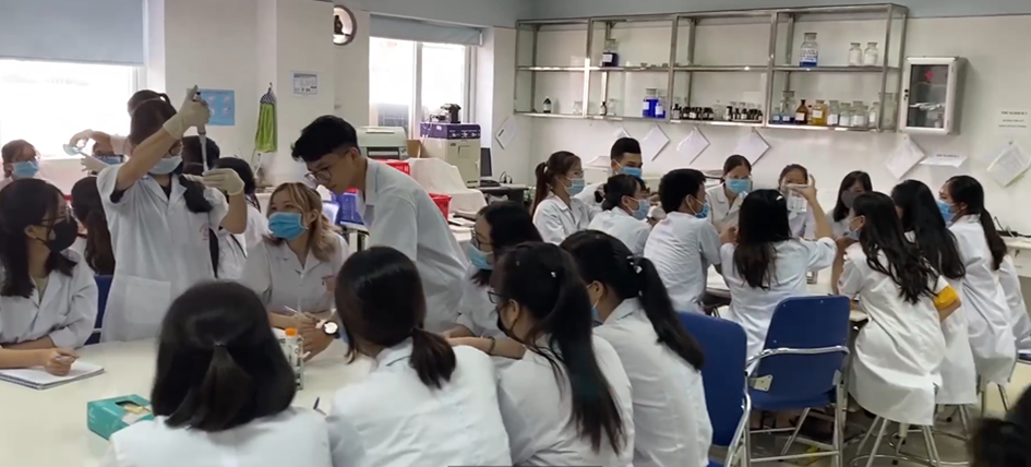 A group of people in lab coats wearing masks

Description automatically generated